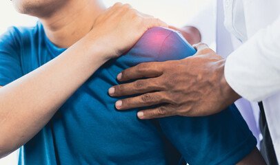 Doctor is diagnosing a man's arm and shoulder pain in a hospital examining room. Male nurse doing physical therapy for a patient.