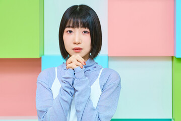 お祈りのポーズをする若い女性とカラフルな背景