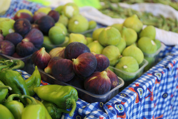 A display of ripe freshly picked figs at the local farmer's market stand. Vitamin packed syconium fruits. Close up, copy space, top view, background.