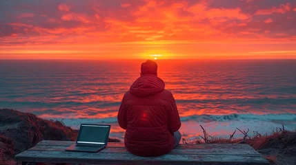 Foto op Plexiglas Solo Man traveler gazes at ocean, sitting at wooden table with laptop, working remotely, a beautiful North landscape on the background © Anna Zhuk
