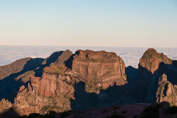 Panoramic view of majestic mountain ridges at sunrise seen from top of Pico do Areeiro, Madeira island, Portugal, Europe. First sunlight touching unique rock formations. Idyllic hiking trail at dawn