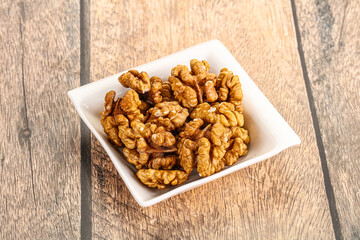 Cracked unshelled walnut in the bowl