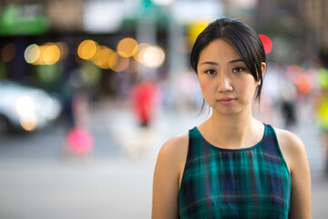 Asian woman serious sad face on city street portrait