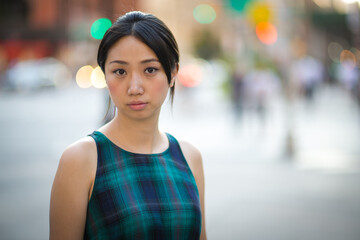 Asian woman serious sad face on city street portrait