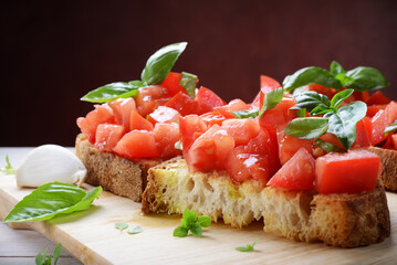 Tomato bruschetta with tomato, basil, garlic and extra virgin olive oil, close-up, space for text.