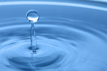 Fototapeta na wymiar Splash of clear water with drop on light grey background, closeup. Space for text