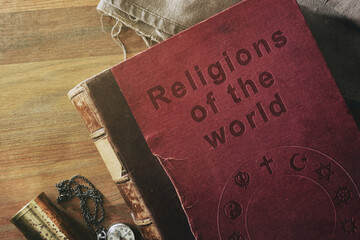 Vintage detail of book of world religions on wooden table