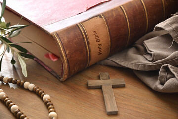 Antique bible on wooden table with wooden christian cross