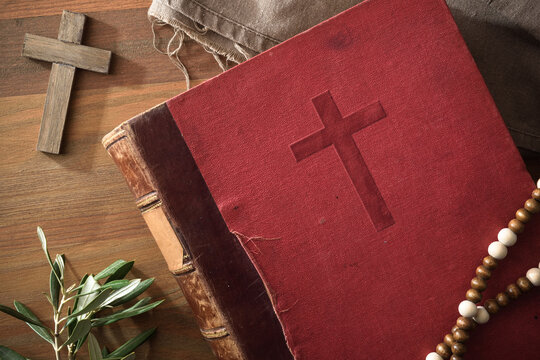 Bible on wooden table with cross olive leaves and decoration