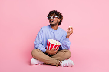 Full body photo of attractive young man watch movie look empty space dressed stylish blue clothes isolated on pink color background