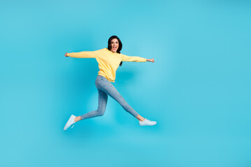 Fototapeta na wymiar Full body photo of young girl jumping dressed stylish outfit isolated on blue color background