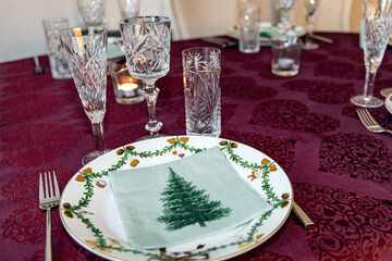 Set Christmas table with Christmas plate and crystal glasses.