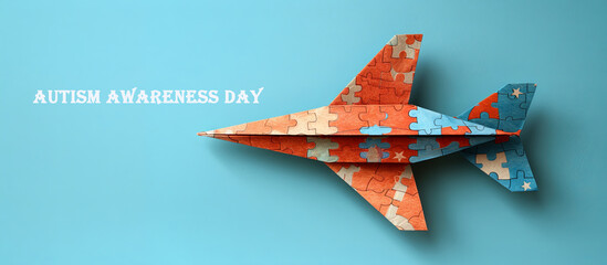 Airplane made of jigsaw puzzle pieces on blue background, autism awareness day concept