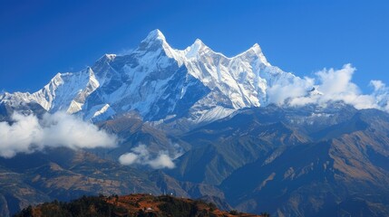 Naklejka premium This is a beautiful landscape image of a snow-capped mountain range. The sky is clear and blue, and the sun is shining brightly.