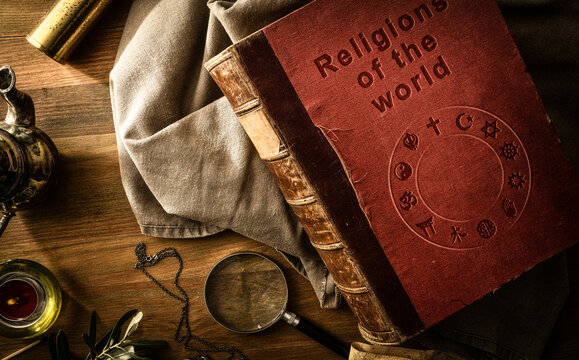 Old book of religions with ancient objects on vintage table