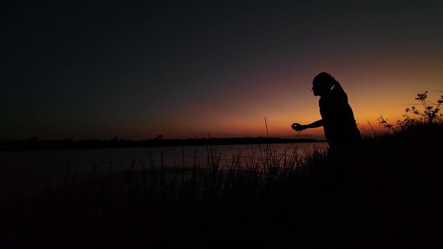 Fishermen cast their nets to catch fish in the pond.