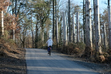 FU 2023-02-20 SiegHennef 203 Auf der Straße fährt ein Radfahrer in den Wald hinein