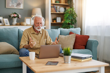 Active pensioner working from home with laptop