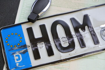 a broken license plate with car keys after an accident
