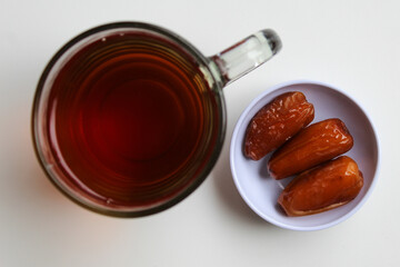 Deglet noor or deglet nour or date palm or dates, with a glass of tea, isolated on white background, flat lay or top view