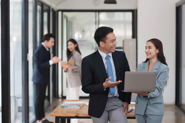 Young motivated Asian business team discussing oh business strategy in the modern meeting room.