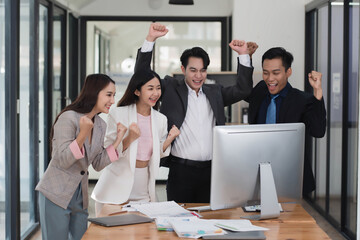 Successful young Asian business team feeling excited and happy from the good news.