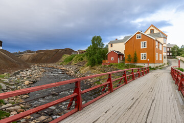 In Roros, a red bridge over the Glomma River provides a picturesque entrance to a street lined with...