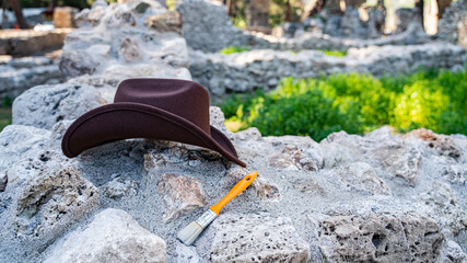 Archaeologist's hat on ancient ruins during excavations as a symbol of archaeology and...