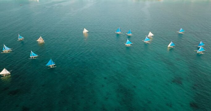 Top view of paraw sailing boats running over the turquoise water. Boracay, Philippines.