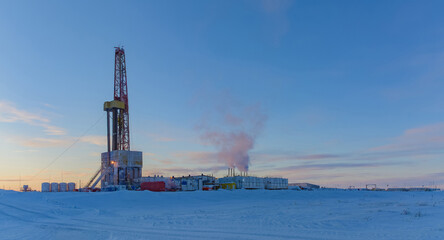 Drilling rig and equipment for drilling oil and gas wells in the Arctic. Madachag oil and gas field in the Barents Sea. Winter polar day. Blue sky, snowy and frosty weather