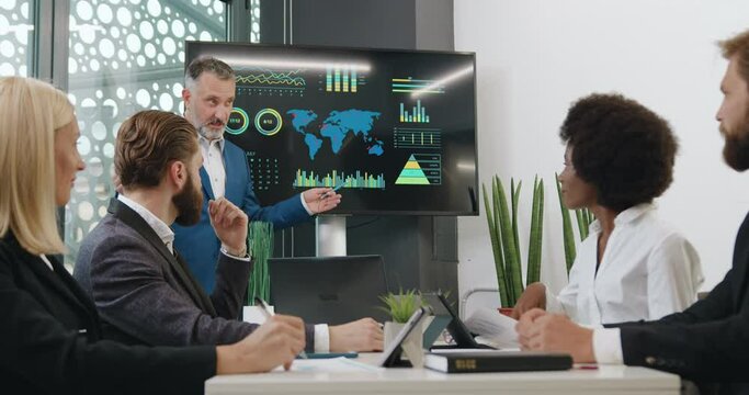 Expert business man using interactive whiteboard to show his multiethnic attentive listeners problematic ecological zones on our earth