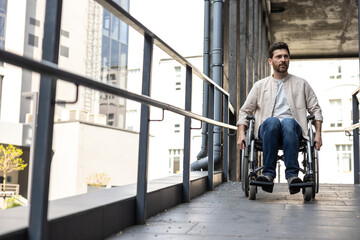 Dark-haired bearded young man on a wheelchair