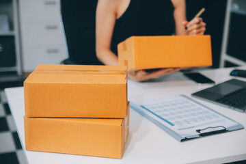 businesswoman start small business and successful SME entrepreneurs asian woman hoding boxs works from home delivering parcels online. SME delivery concept and packaging