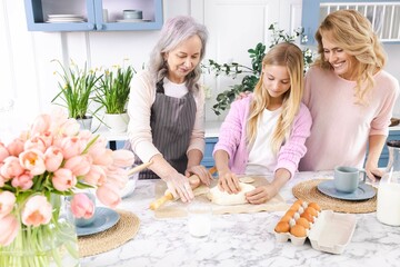 Granny and mom teaching grandchild to make dough using flour and eggs in kitchen. Concept of...