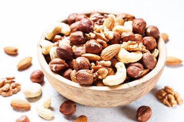 Nuts assortment at white background. Almond, hazelnut, cashew in wooden bowl.