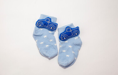 cute blue baby socks with car accessories on white background