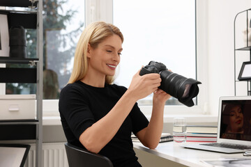 Professional photographer with digital camera at table in office