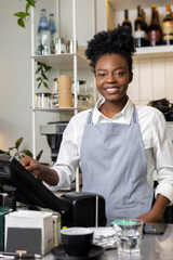 Woman waitress barista bartender checking bill before printing it on digital cash register