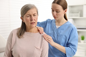 Arthritis symptoms. Doctor examining patient with shoulder pain in hospital