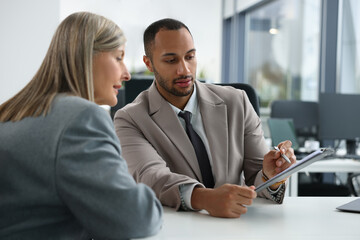 Lawyers with clipboard working together at table in office