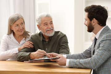 Notary consulting senior couple about Last Will and Testament in office