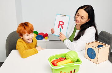Professional speech and language therapist helping child patient with stuttering and difficulty in...