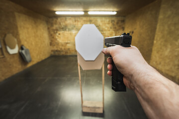 Shooting a pistol with one hand at a shooting range at an ipsc target.