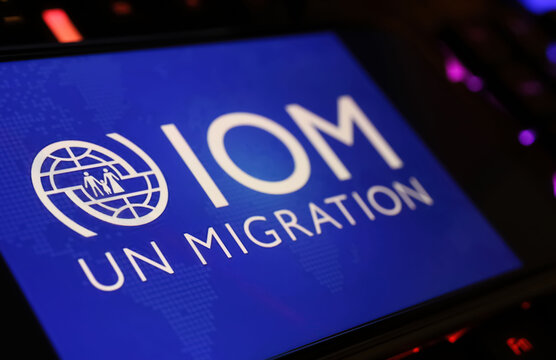 Viersen, Germany - January 9. 2024: Smartphone screen with logo lettering of UN agency International organization for Migration IOM  on computer keyboard