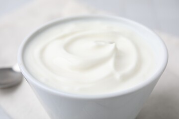 Obraz na płótnie Canvas Delicious natural yogurt in bowl on table, closeup