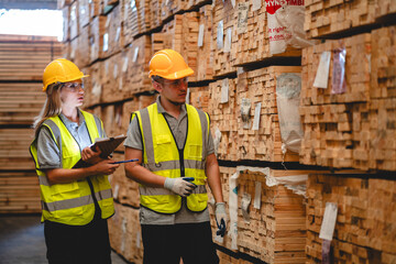 Man and woman workers with clipboard discussing working and checking stock inventory wood plank...