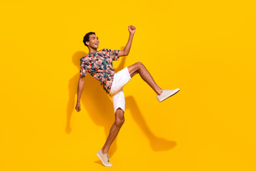 Fototapeta na wymiar Full body length photo of funky young guy big steps motion looking empty space brand summertime clothes isolated on yellow color background