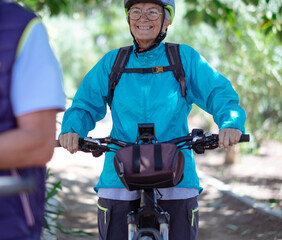 Obraz premium Happy active cyclist senior woman wearing bicycle helmet enjoys beautiful day outdoors. Smiling elderly grandmother running in nature, retired healthy lifestyle