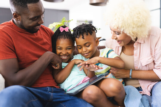 African American family enjoys time together, with the father showing something on a tablet