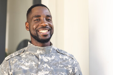 African American soldier in military uniform smiles warmly with copy space